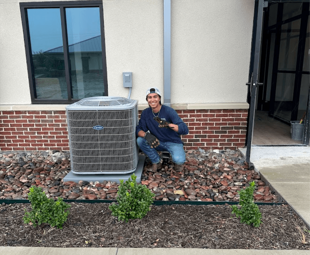 Emilio from JC Air Pro standing next to a freshly installed AC condenser at a DFW home.